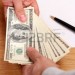 9282883-businessmen-passing-money-with-contract-on-the-background